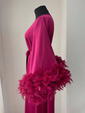 A mannequin wearing a long pink robe with a large feather trim, displayed against a white background.