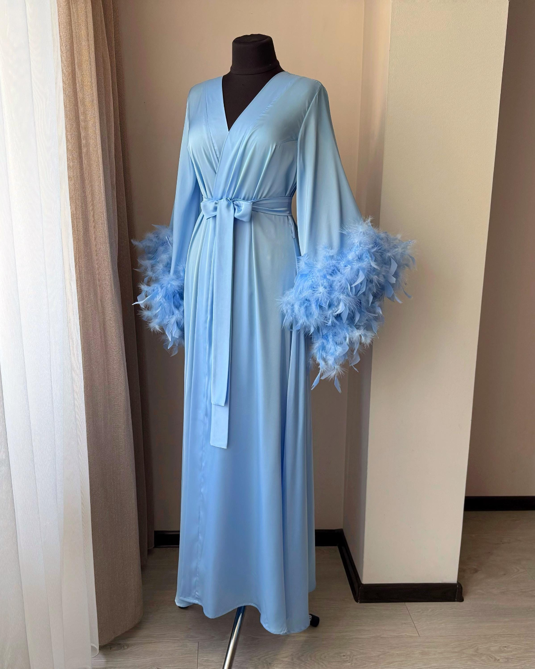 a woman's blue dress with feathers on it