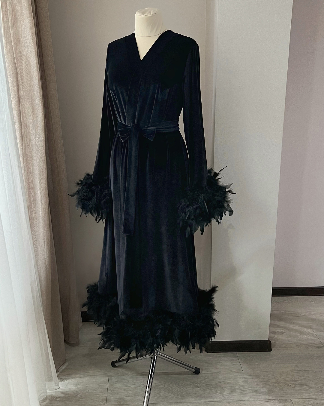 a black dress with feathers on a mannequin