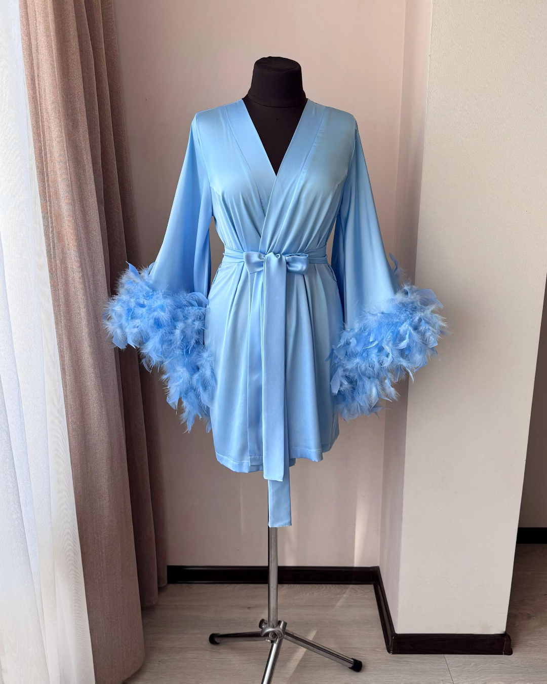 a blue robe with feathers on a mannequin