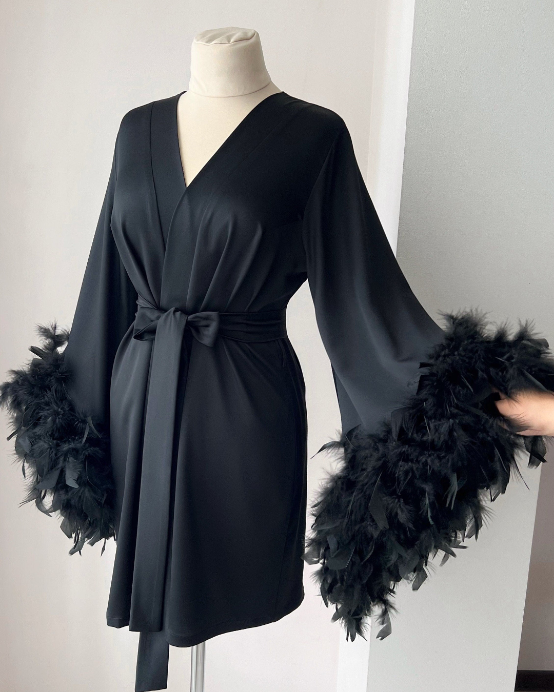 a black dress with feathers on a mannequin