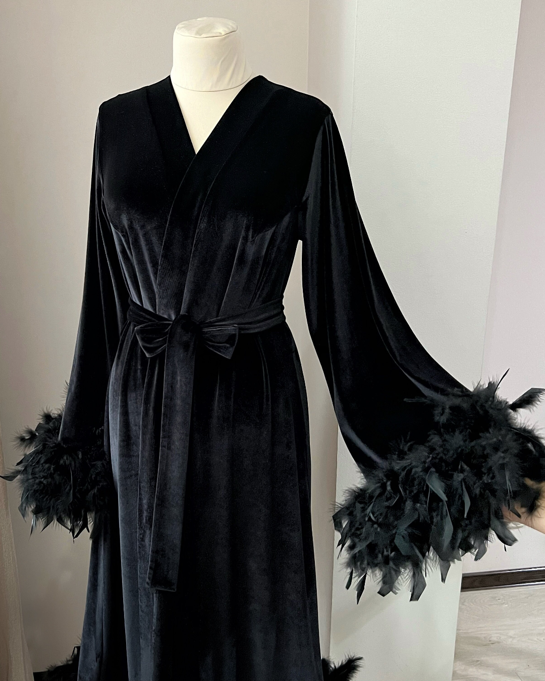 a black dress with feathers on a mannequin