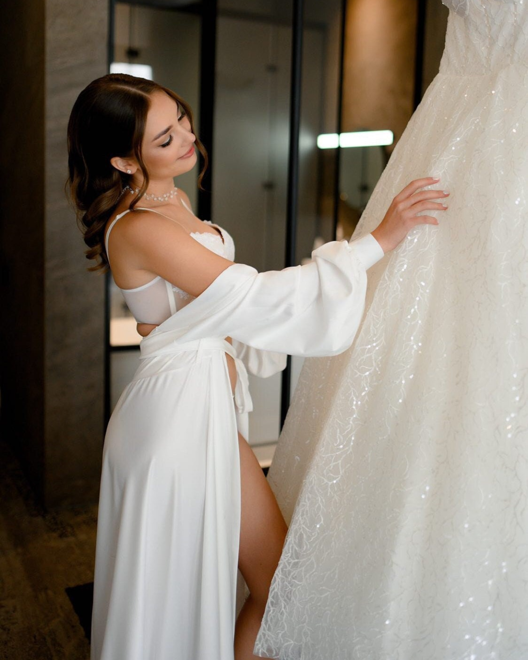 наречена в білому халатів розглядаєм весільне плаття