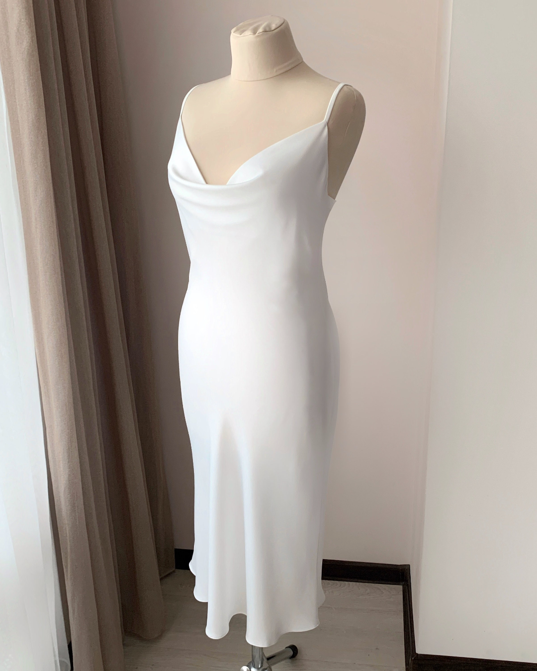 a white dress on a mannequin in a room